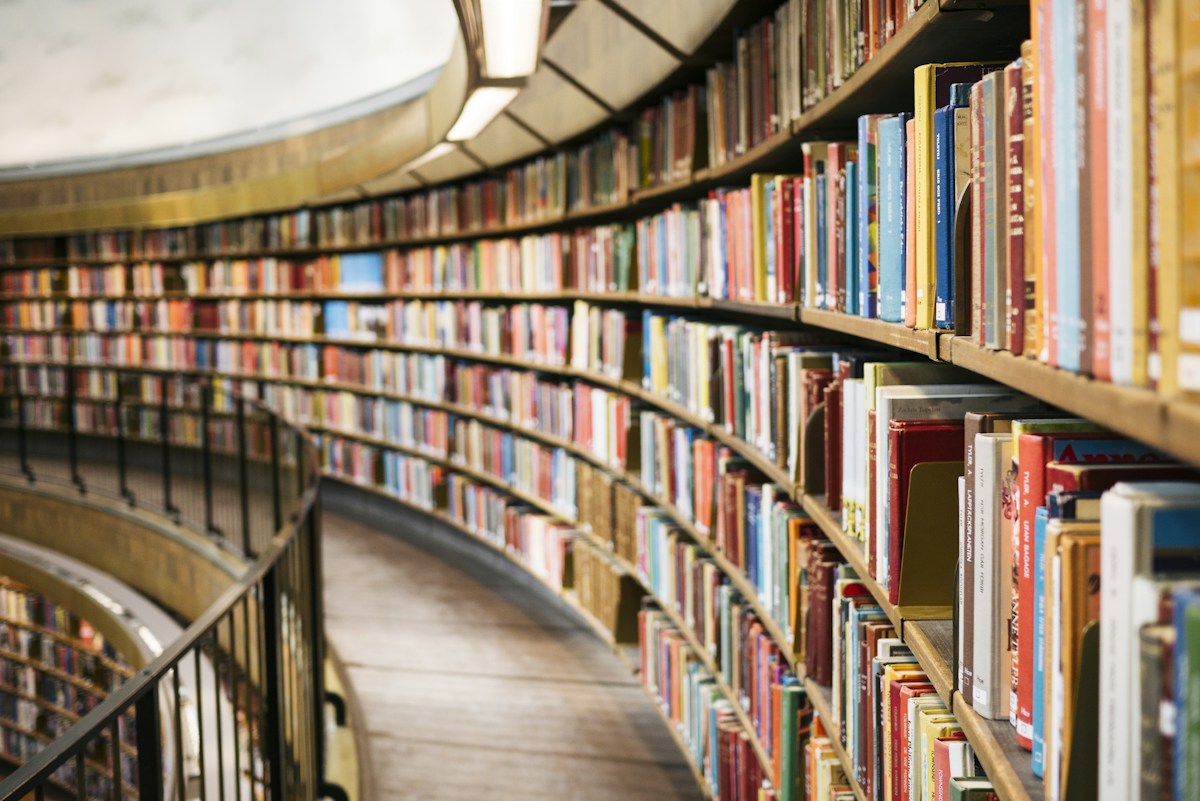 Curved shelves filled with books in a large library