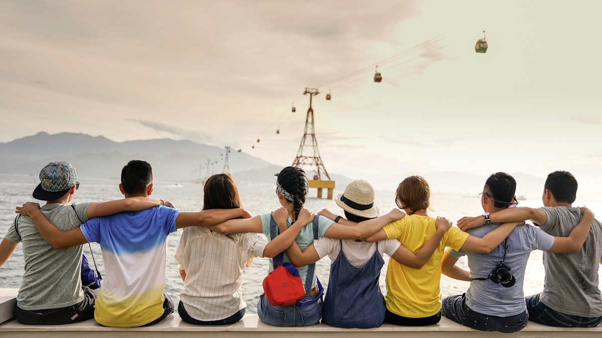 A group of people seated together with their arms around one another